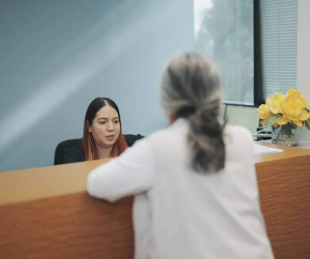 A visitor talking with staff at the K Wellness front desk