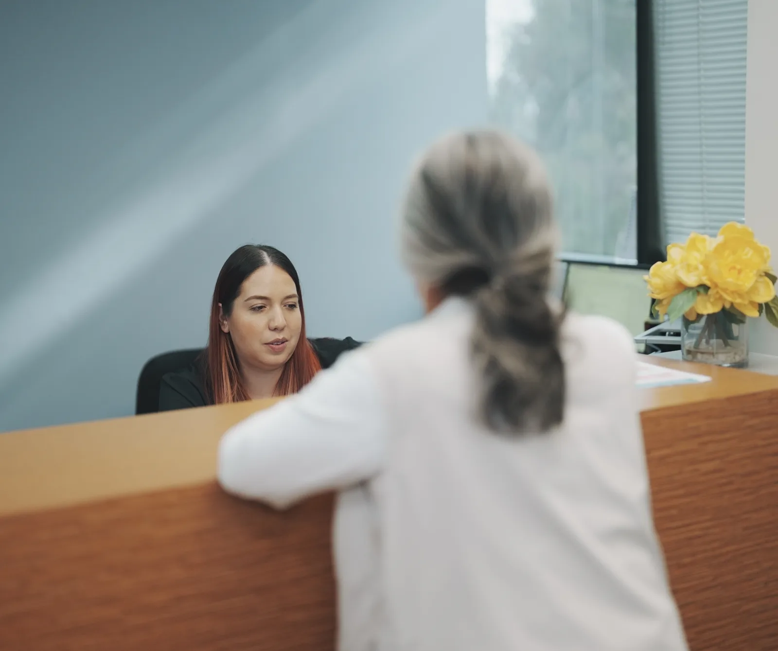 A visitor talking with staff at the K Wellness front desk