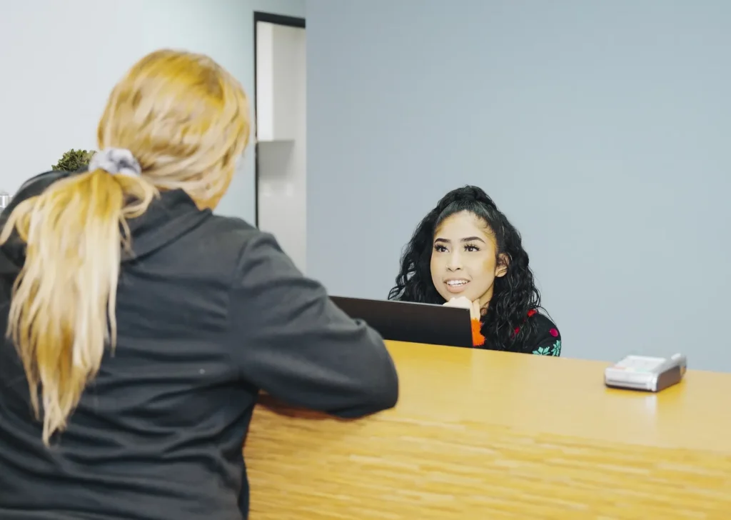 A visitor talking with the K Wellness front desk