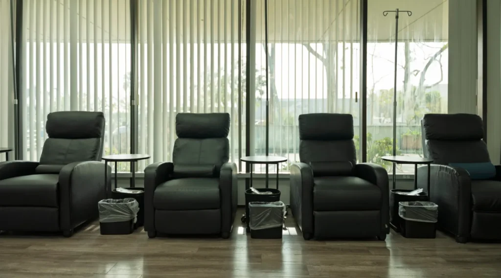 Four reclining chairs with side tables by the windows in the K Wellness IV room