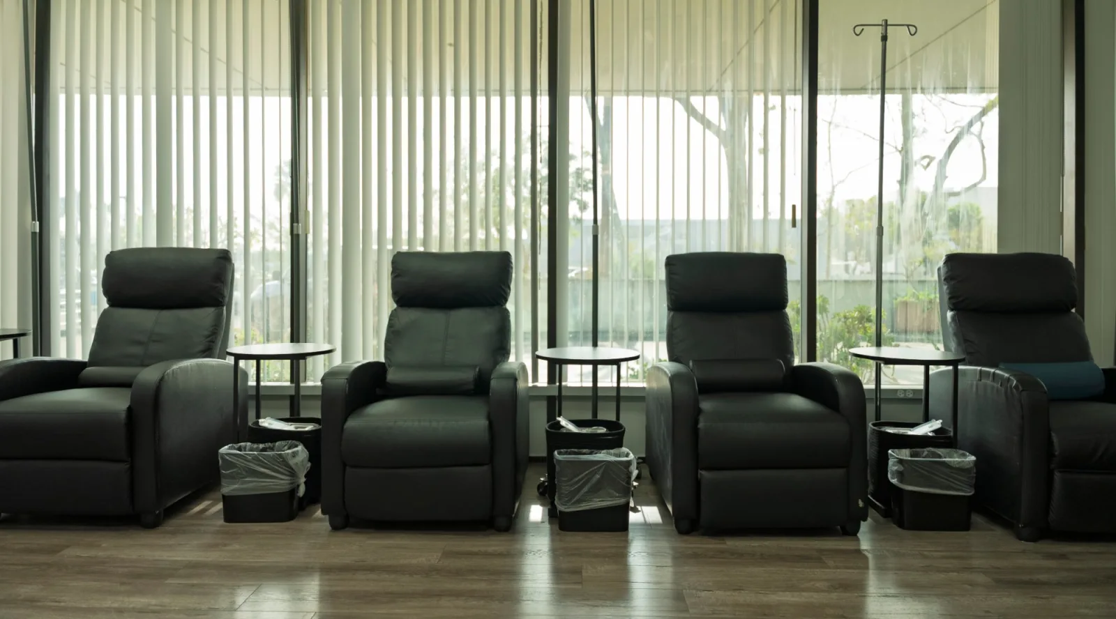 Four reclining chairs with side tables by the windows in the K Wellness IV room