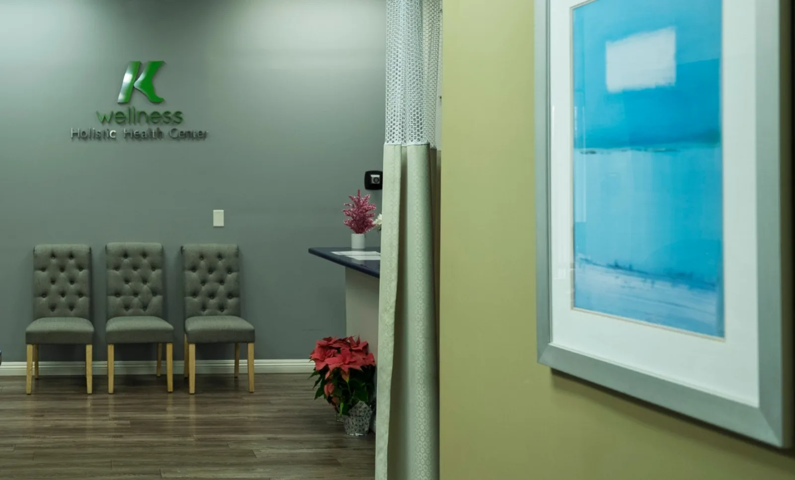 The K Wellness waiting area, with chairs beneath the K Wellness logo on the wall